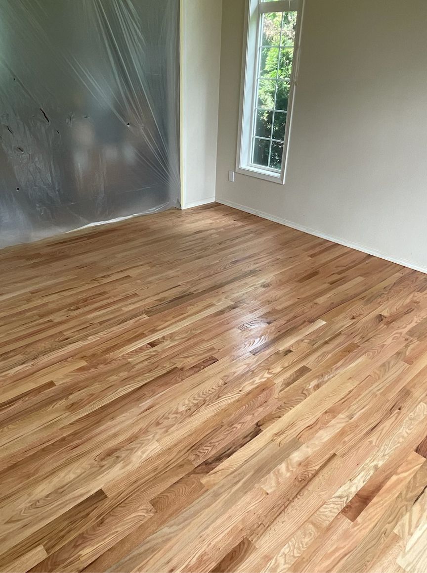 A room with a wooden floor and a window.