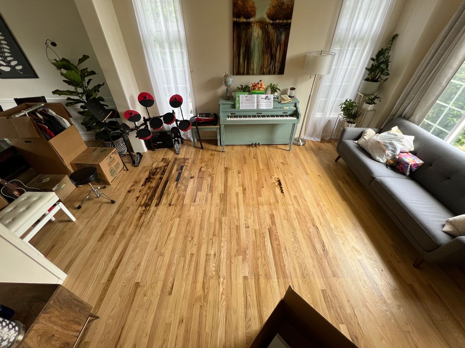 An aerial view of a living room with hardwood floors and a piano.