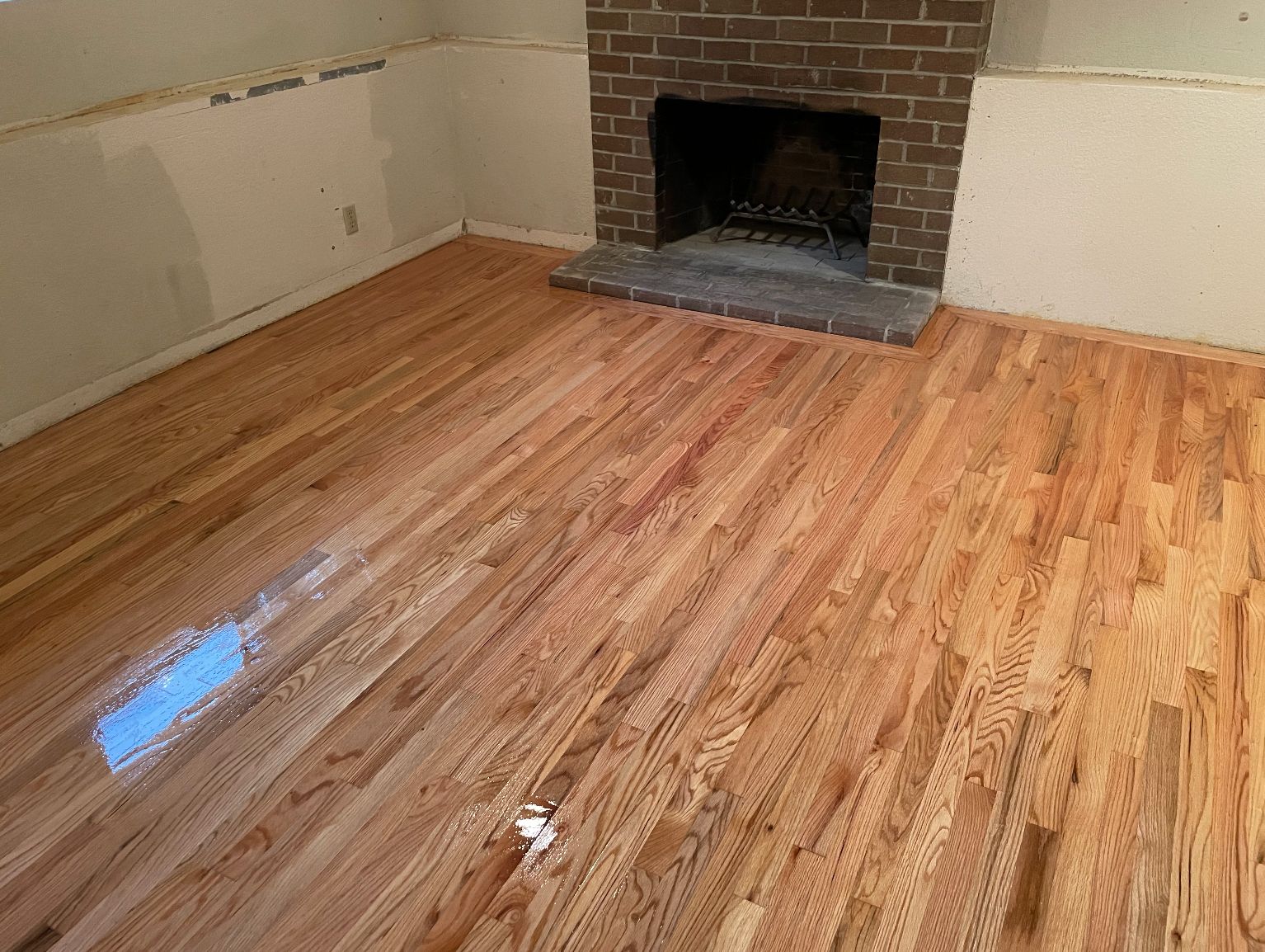 A living room with hardwood floors and a fireplace.