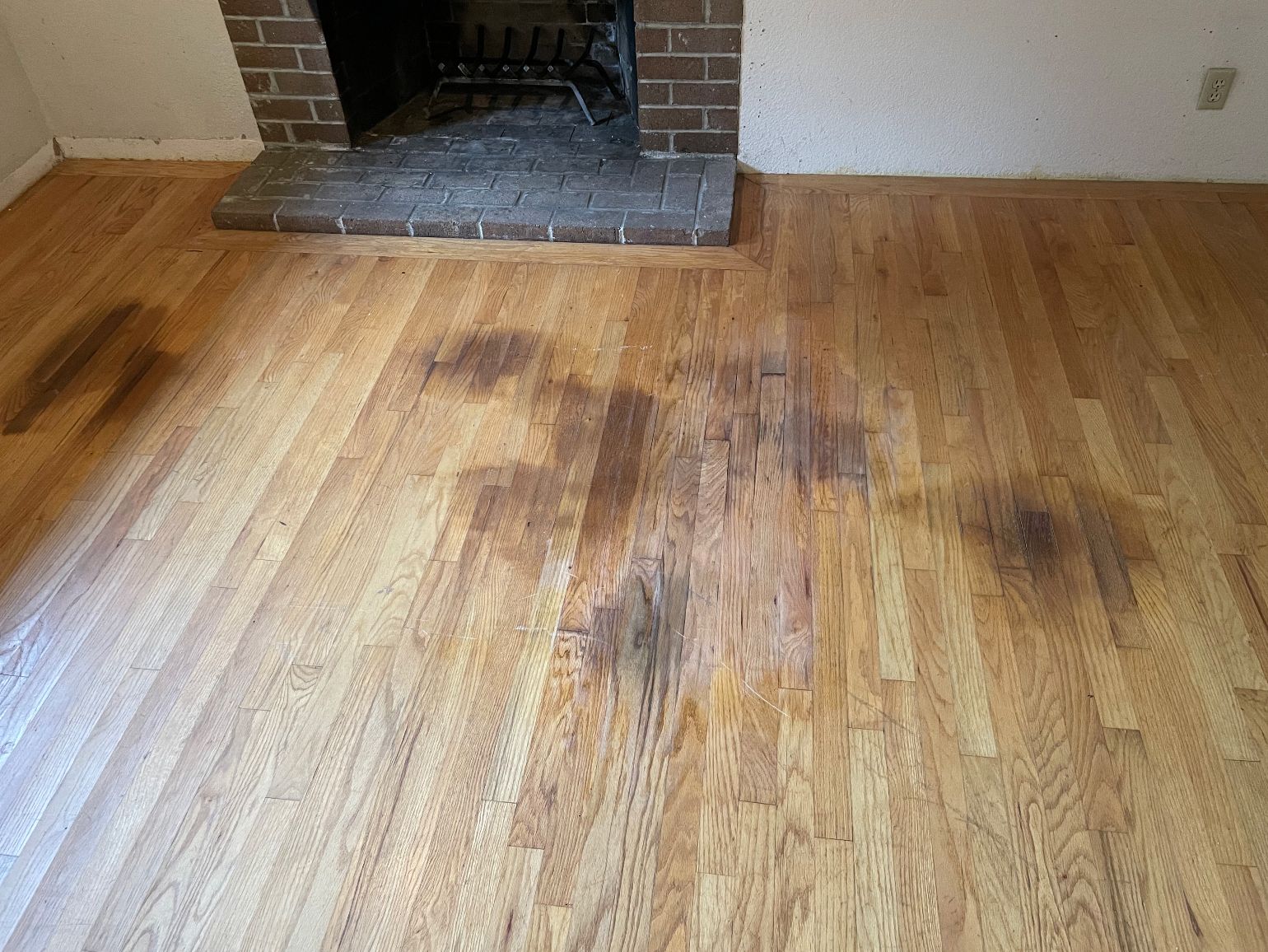 A living room with a wooden floor and a fireplace.