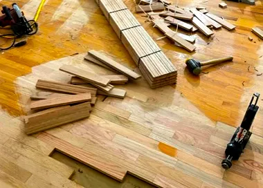 a wooden floor is being installed with tools on it .