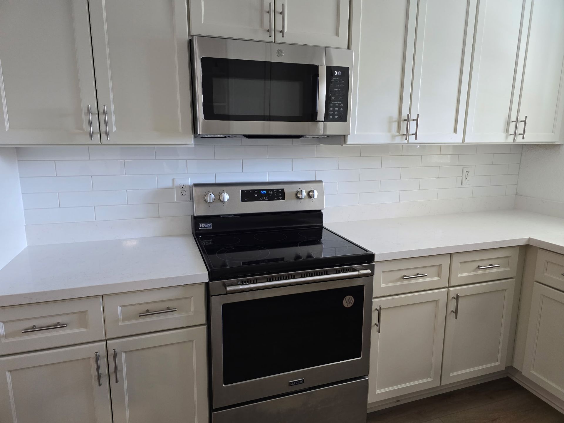A kitchen with stainless steel appliances and white cabinets