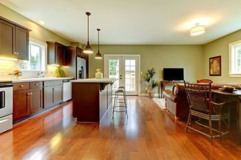 A kitchen and living room in a house with hardwood floors.