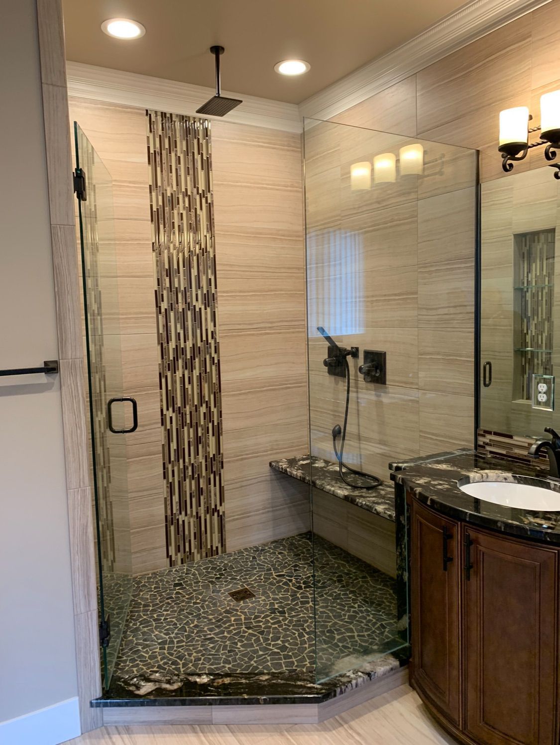 A bathroom with a walk in shower and a sink.