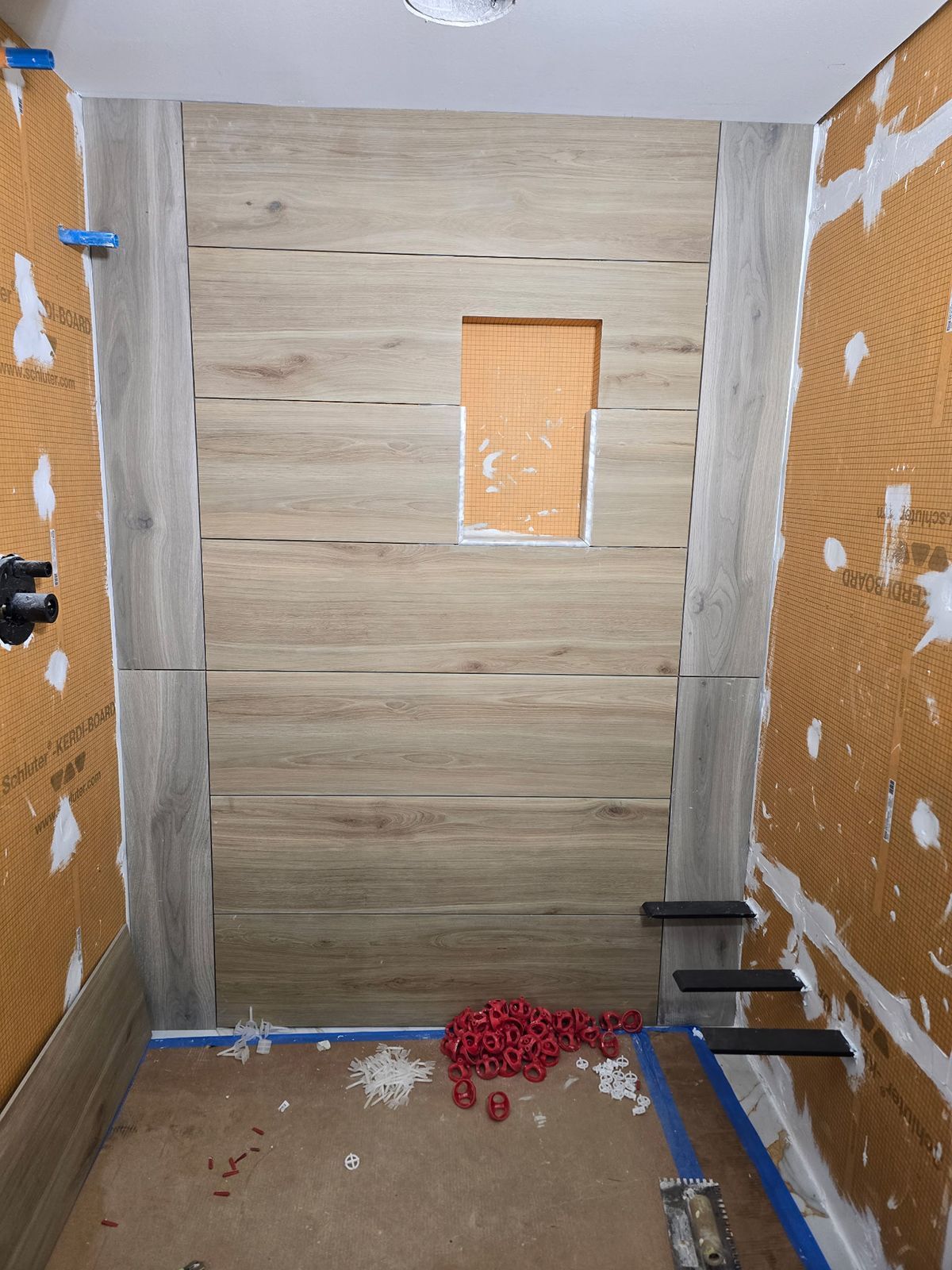 A bathroom under construction with a wooden wall and a window.