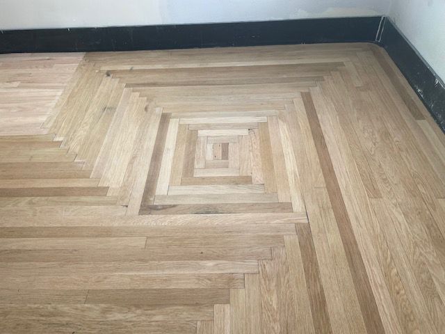 A wooden floor with a square in the middle of it.