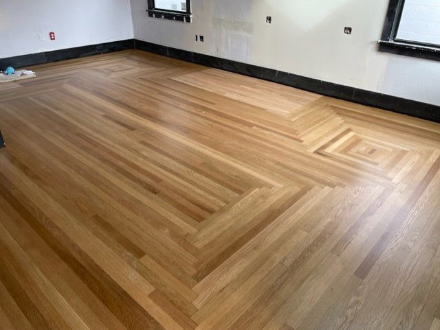 A wooden floor with a herringbone pattern in a room.