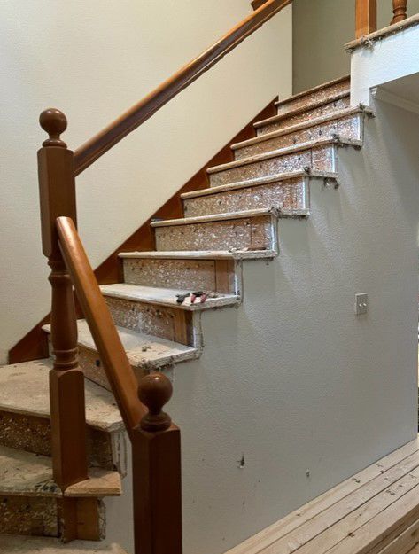 A staircase with a wooden railing and a white wall