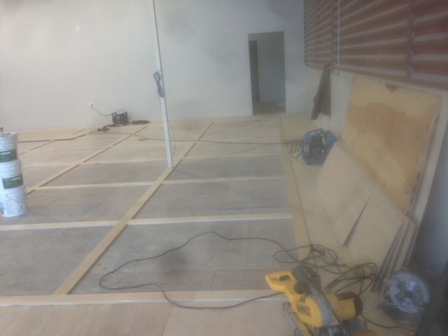 A circular saw is sitting on a wooden floor in a room.