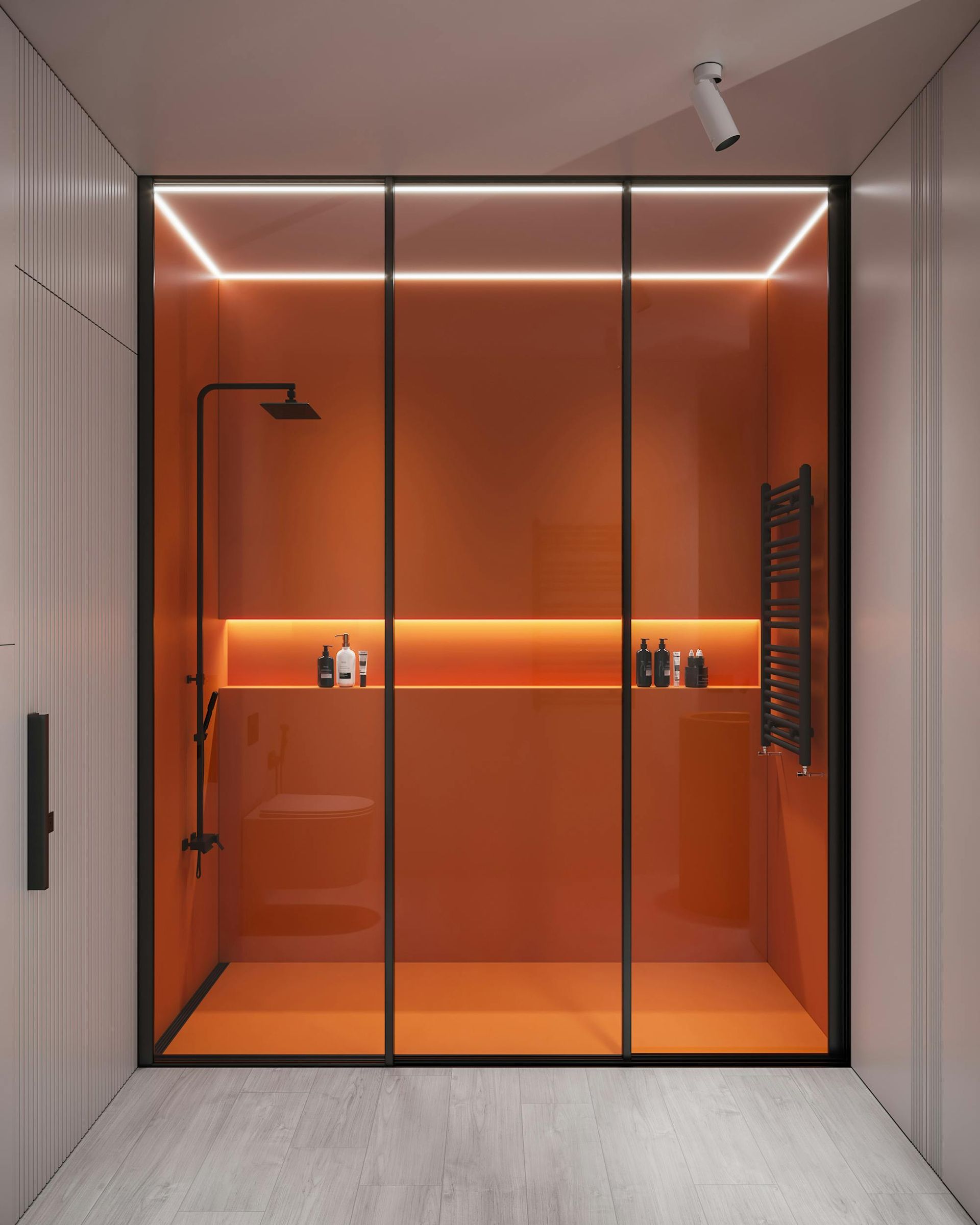 Orange shower enclosure with black fixtures and a built-in shelf. Features linear lighting.