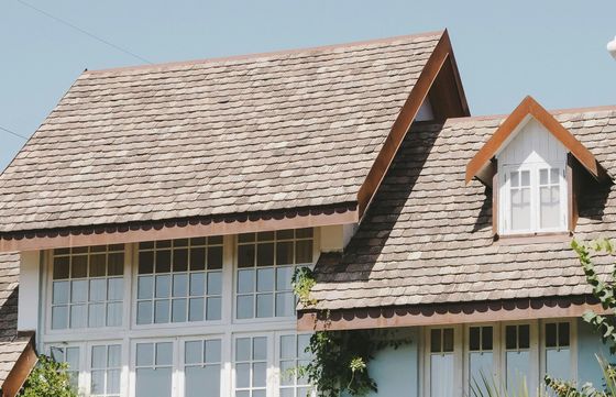 A house with a brown roof and white windows