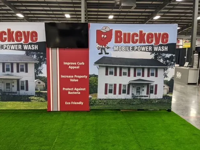 Buckeye Mobile Power Wash booth with red and white panels, house photos, and logo featuring the state of Ohio.