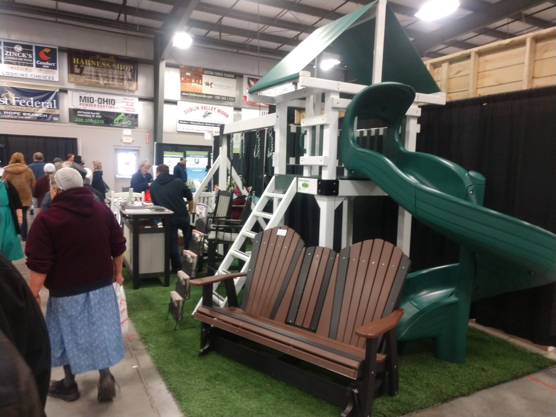 Playground set with green slide and white frame in a store display.