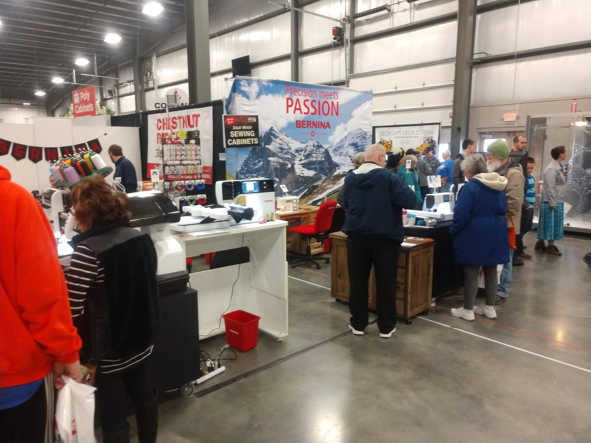 People browse booths at a trade show. A mountain scene banner is visible.