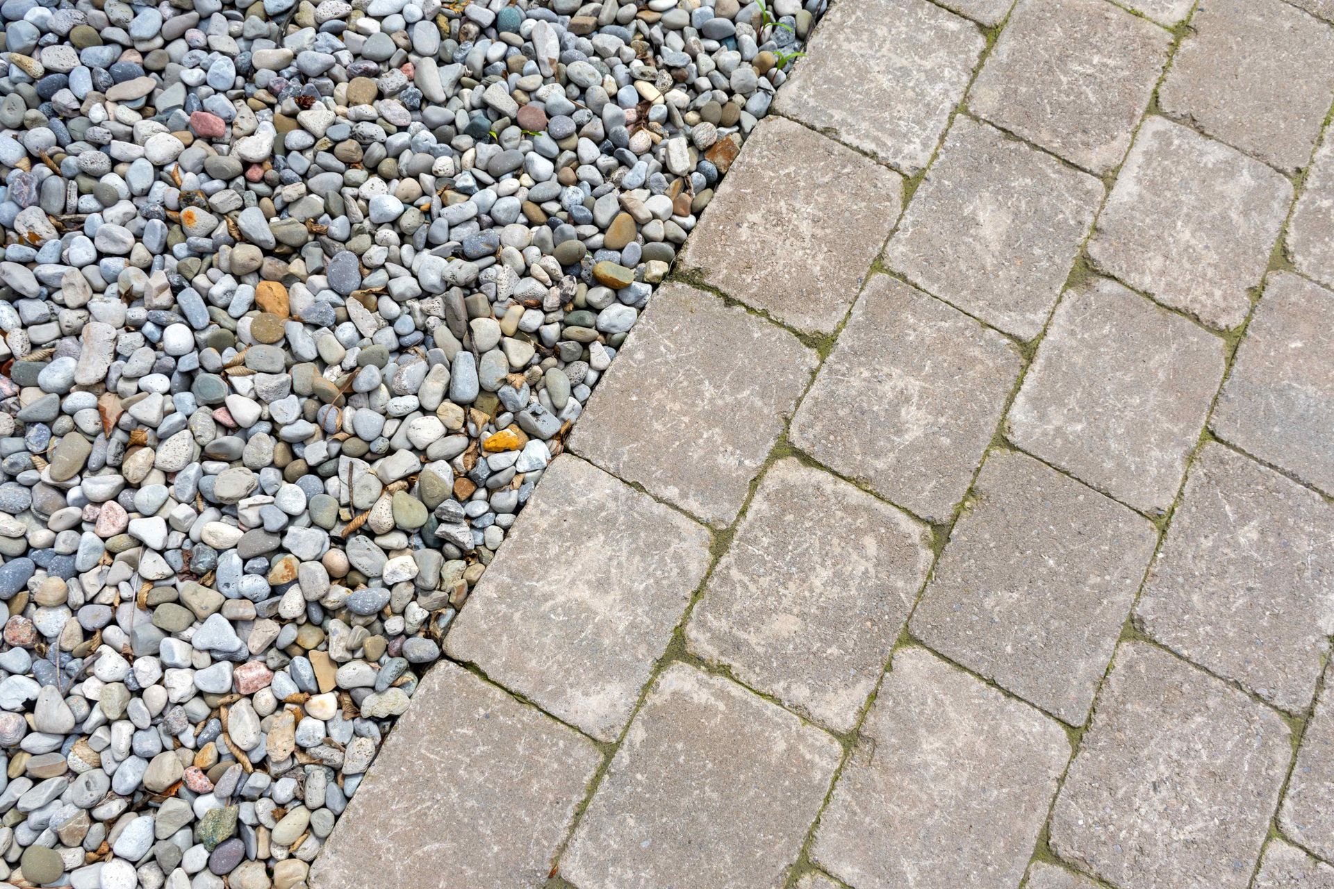 hardscaped paver path next to a riverrock garden bed