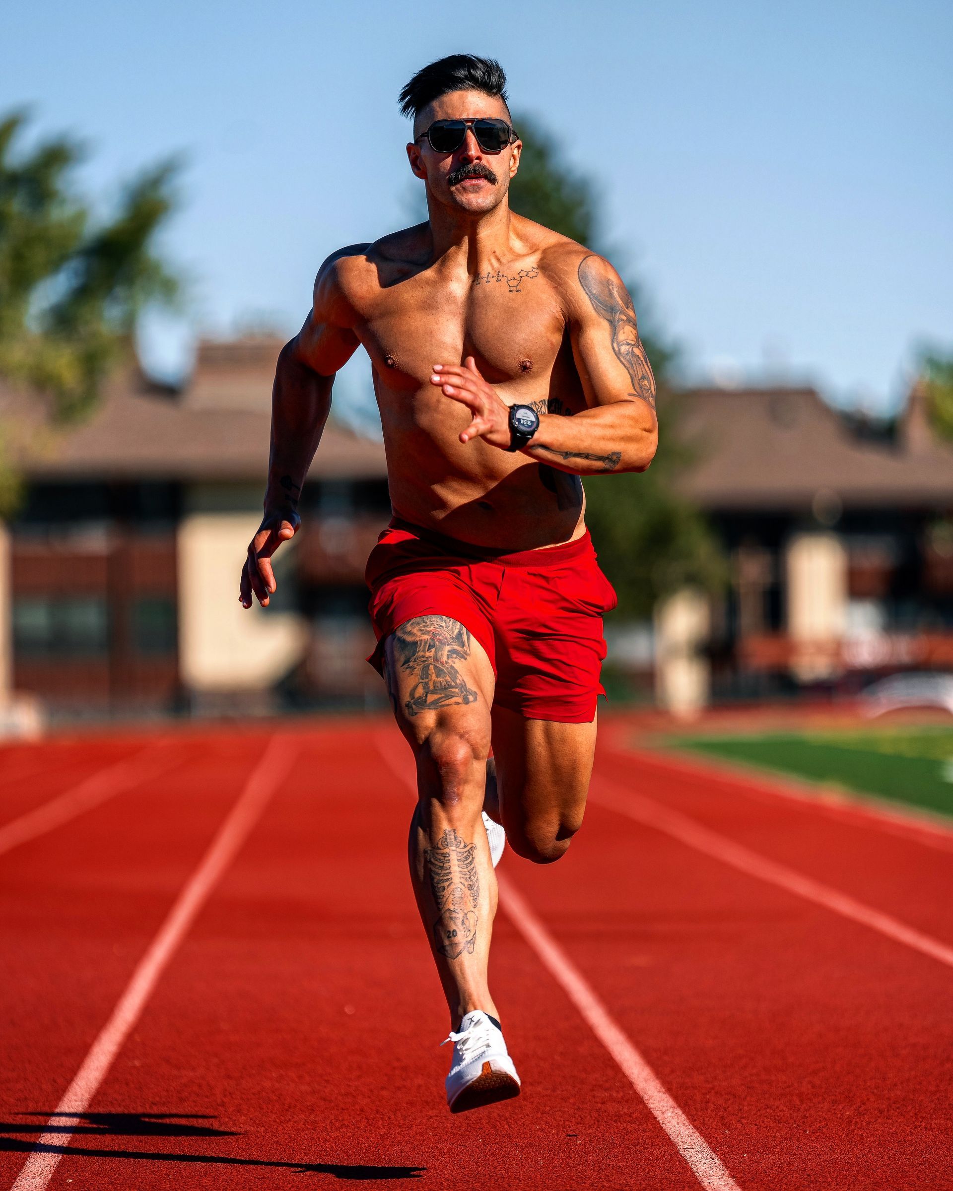 a man with no shirt on running on a track