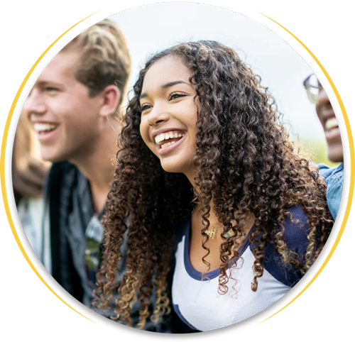 A woman with curly hair is laughing with two other people
