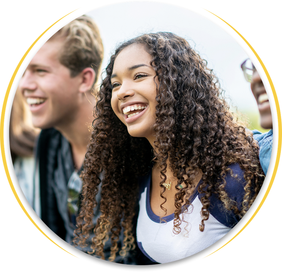 A woman with curly hair is laughing with two other people