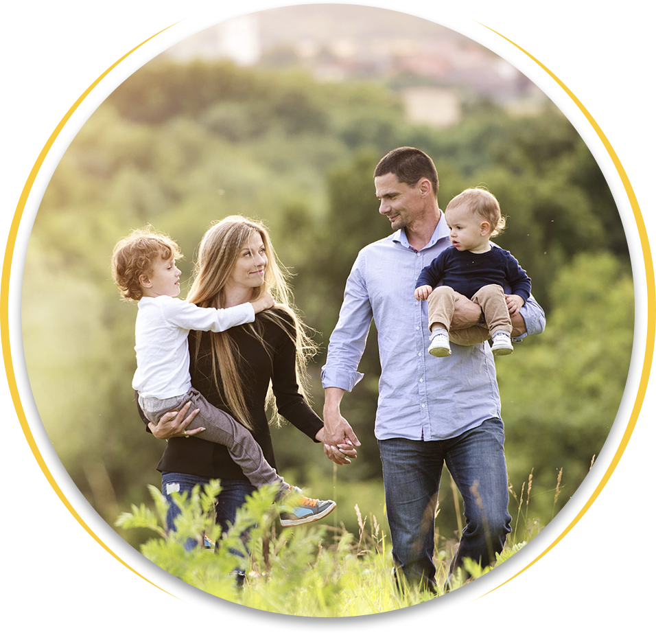 A family is walking through a field holding hands.