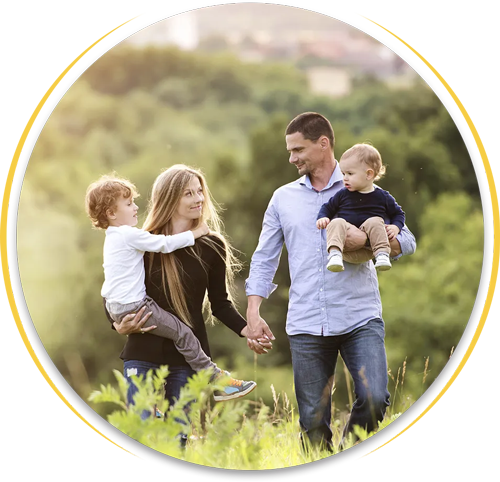 A family is walking through a field holding hands.