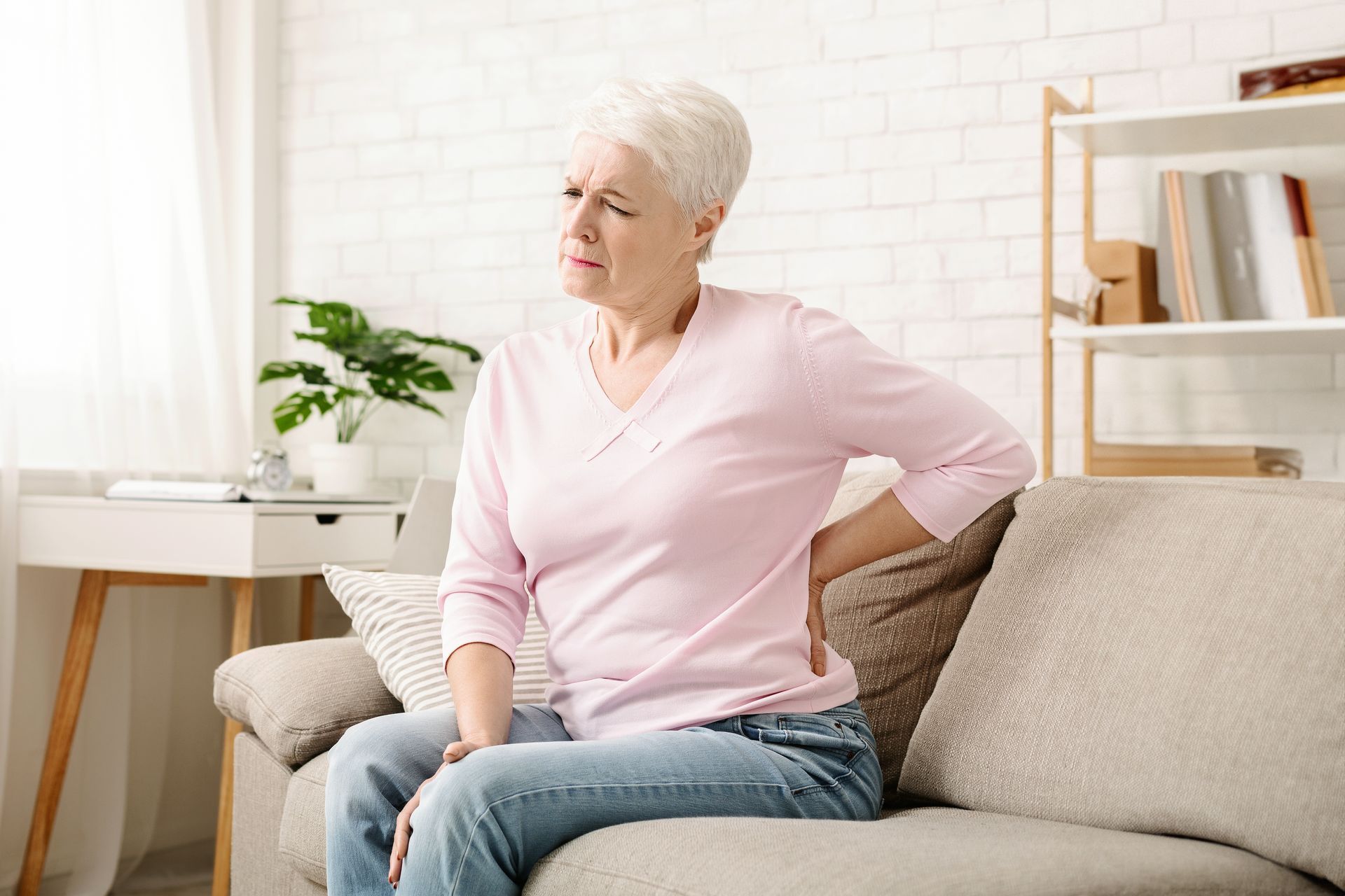 a woman holding her lower back in pain