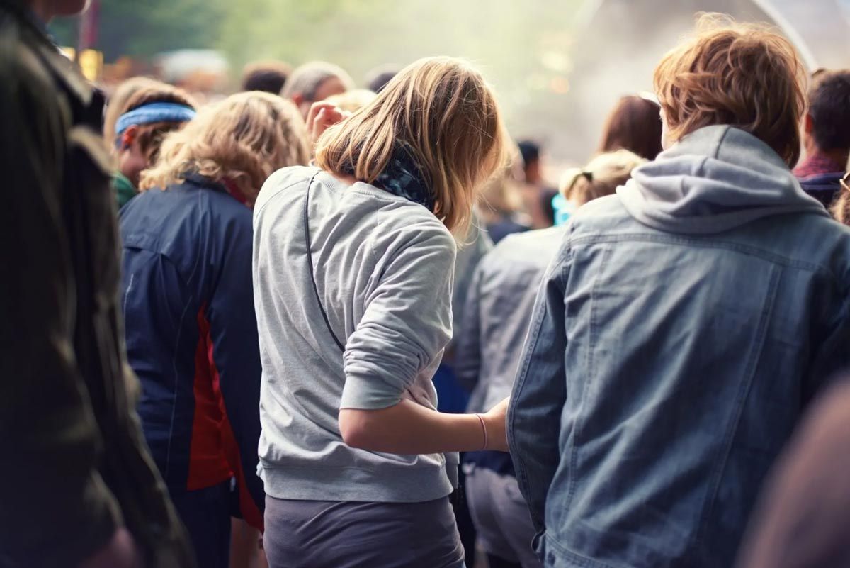 a woman looking at her phone while in a crowd of people