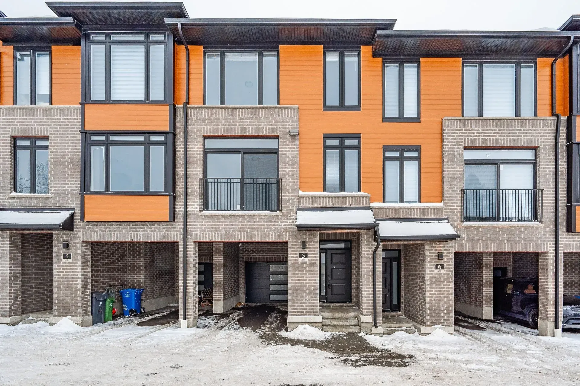 A row of apartment buildings are lined up in a snowy area.
