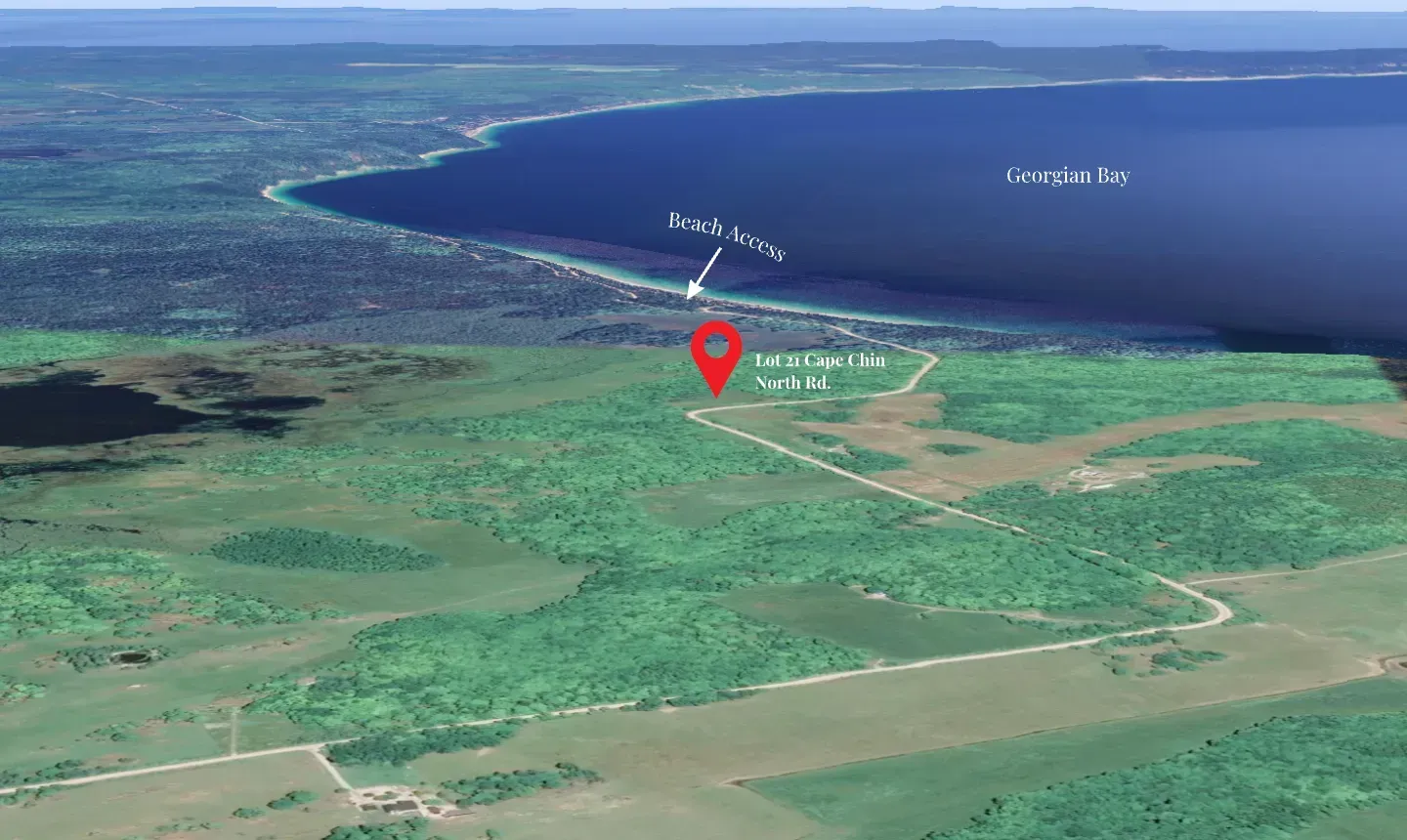 An aerial view of a tropical island with a red pin pointing the location of a beach.