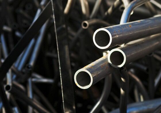 A Bunch of metal Pipes are Stacked on top of each other — Scrap Recyclers in Morisset, NSW
