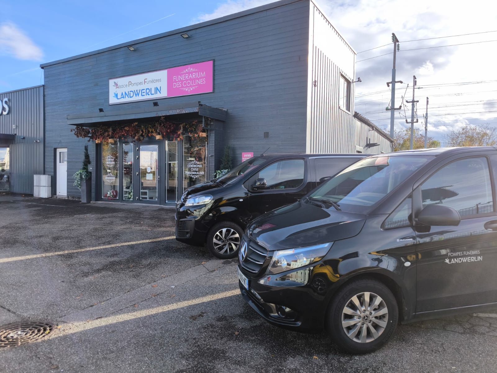 Une maison blanche avec un gros pneu devant.