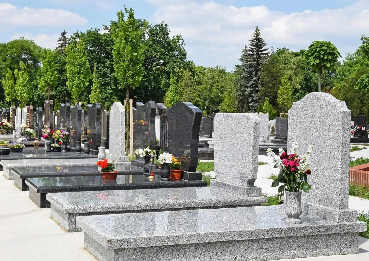 Un cimetière avec beaucoup de tombes et de fleurs dessus