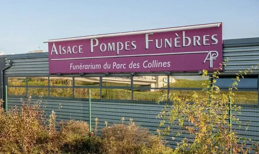 Un panneau sur lequel est écrit Alsace Pompes Funèbres