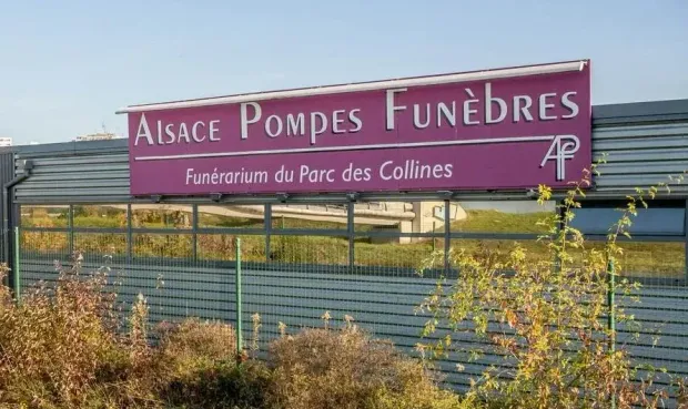 Un panneau sur lequel est écrit " Alsace Pompes Funèbres "