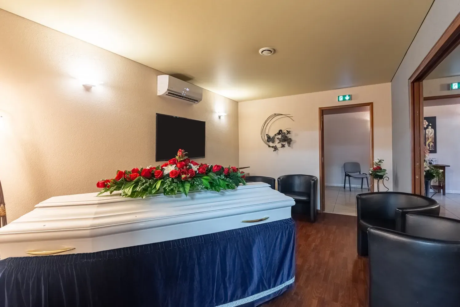 Une pièce avec un cercueil et des chaises à l'intérieur.