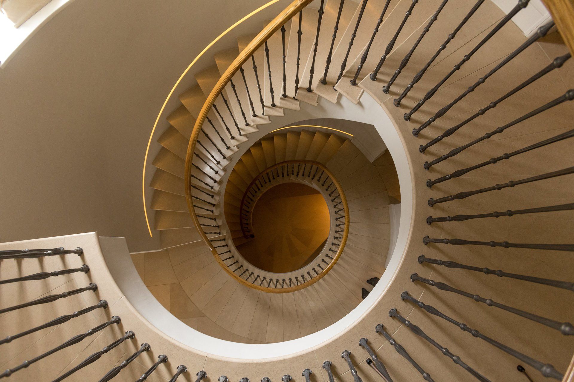 Looking down a spiral staircase with a metal railing