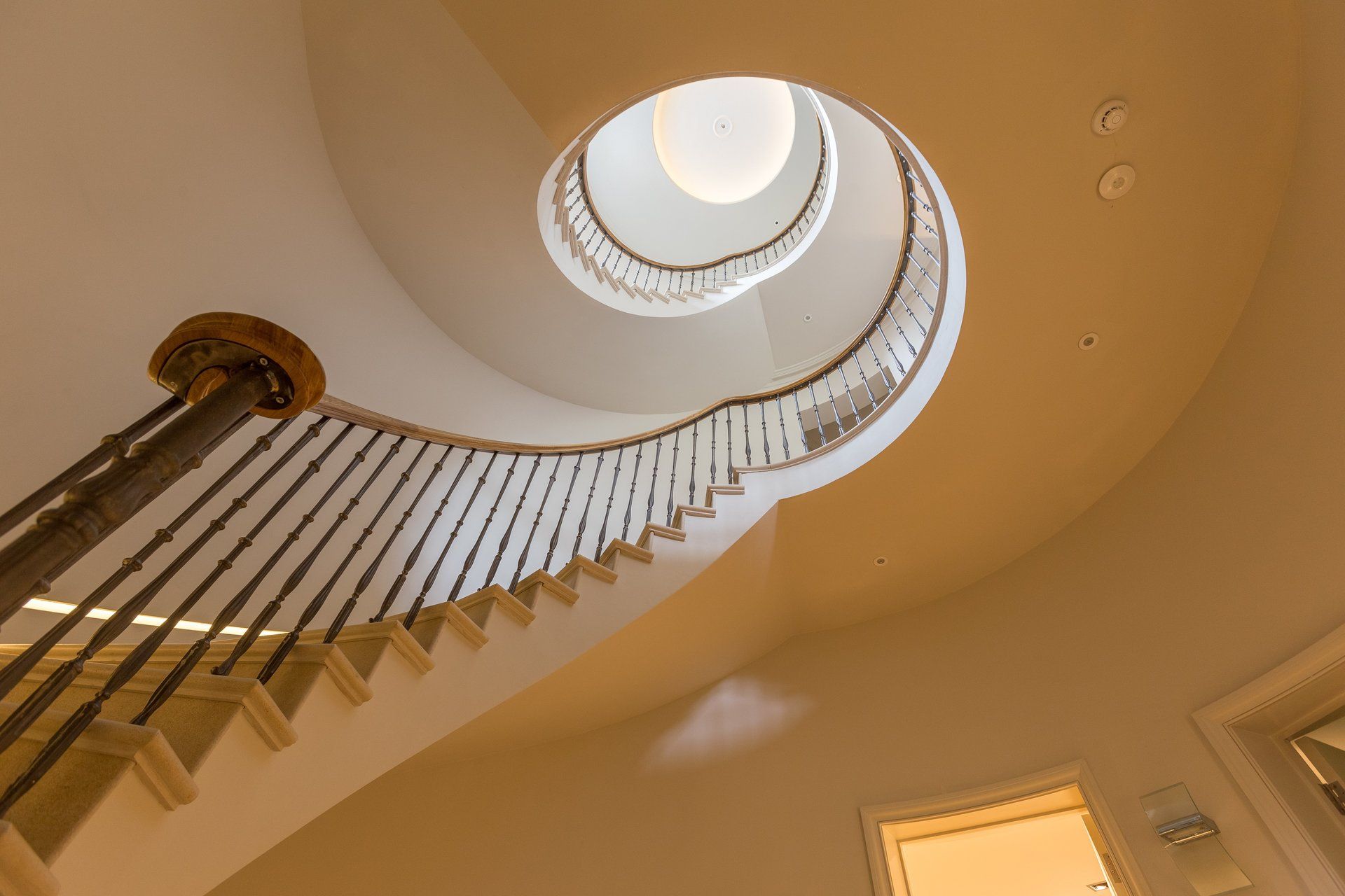 Looking up at a spiral staircase in a house.