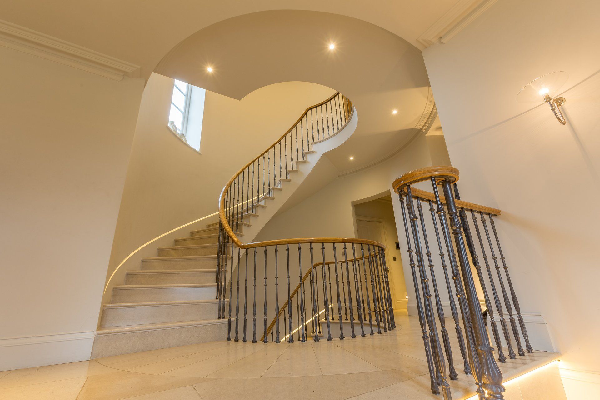A spiral staircase with a wrought iron railing in a house.
