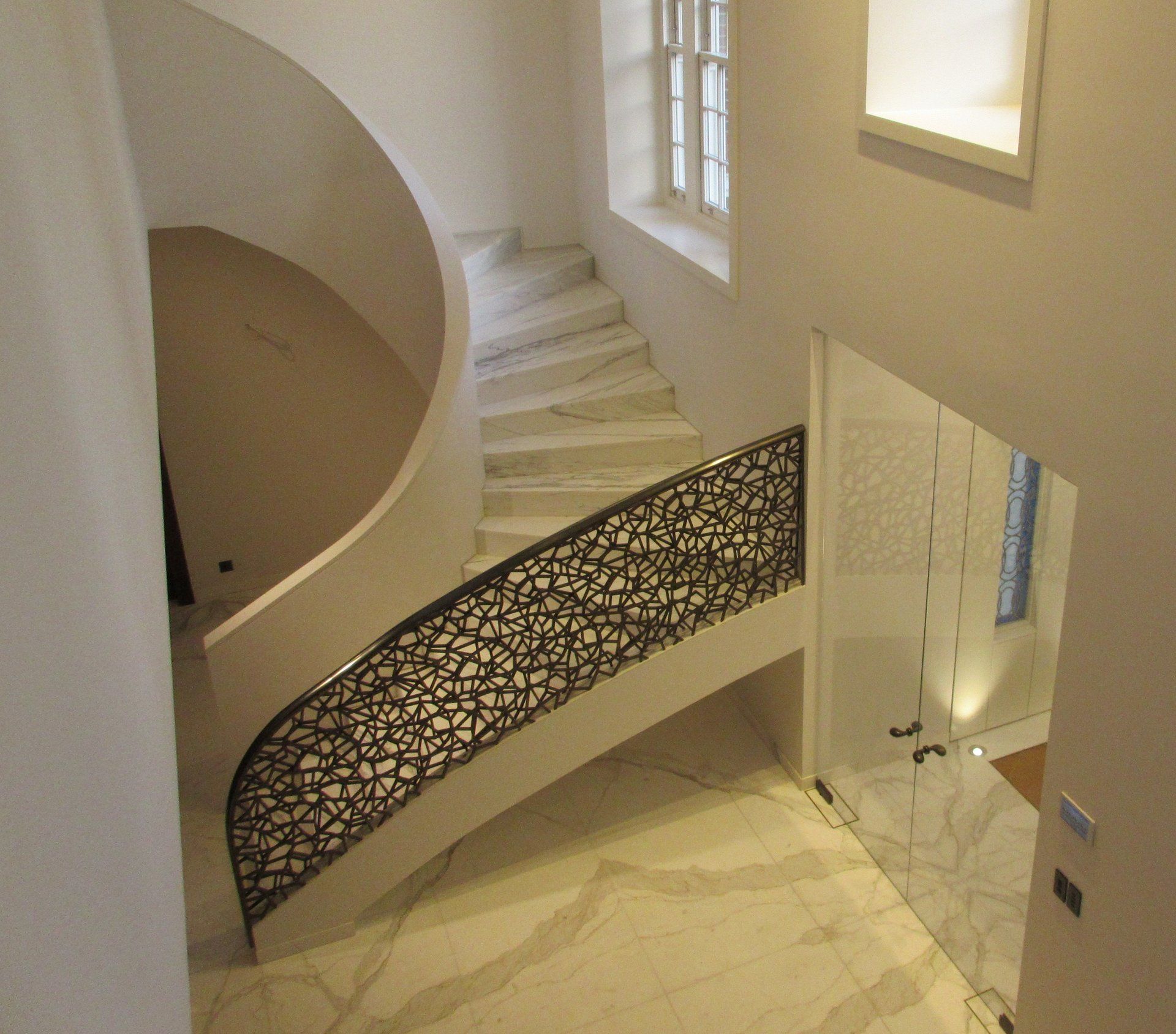 An aerial view of a spiral staircase with a wrought iron railing.