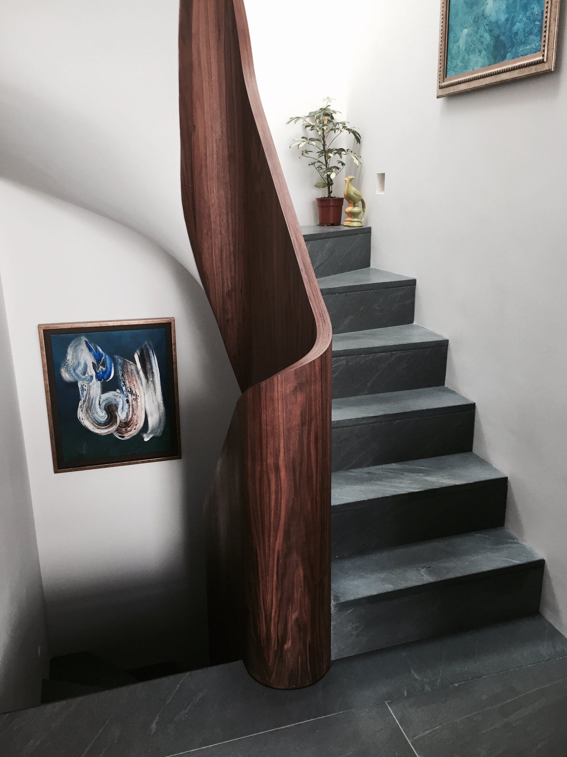 A staircase with a picture on the wall above it