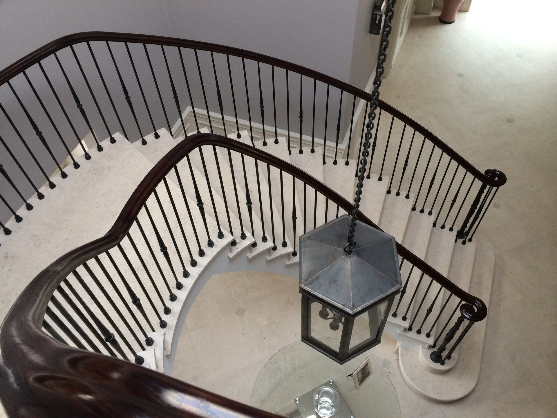A curved staircase with a lantern hanging from the ceiling