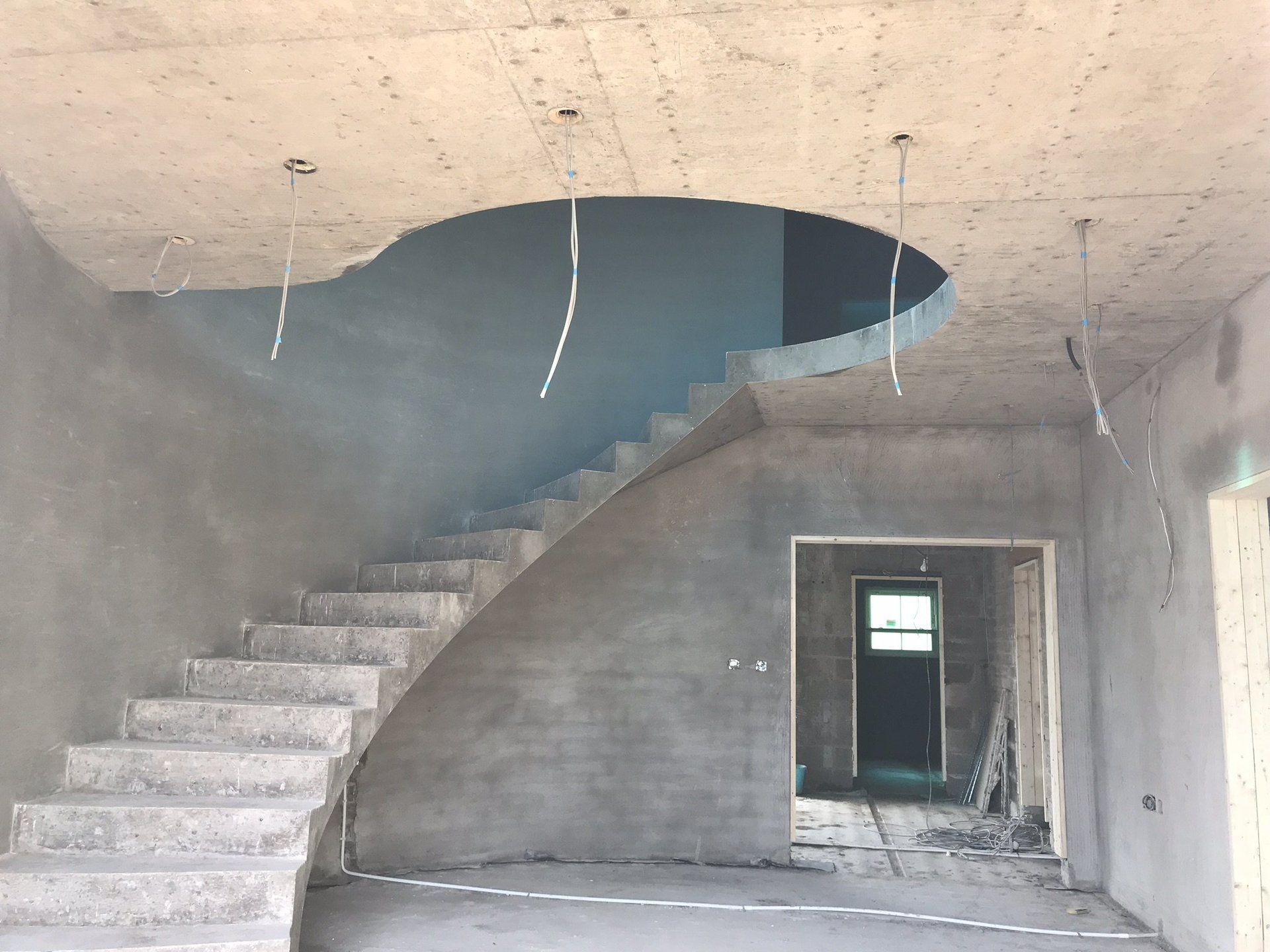 A building under construction with stairs and a hole in the ceiling