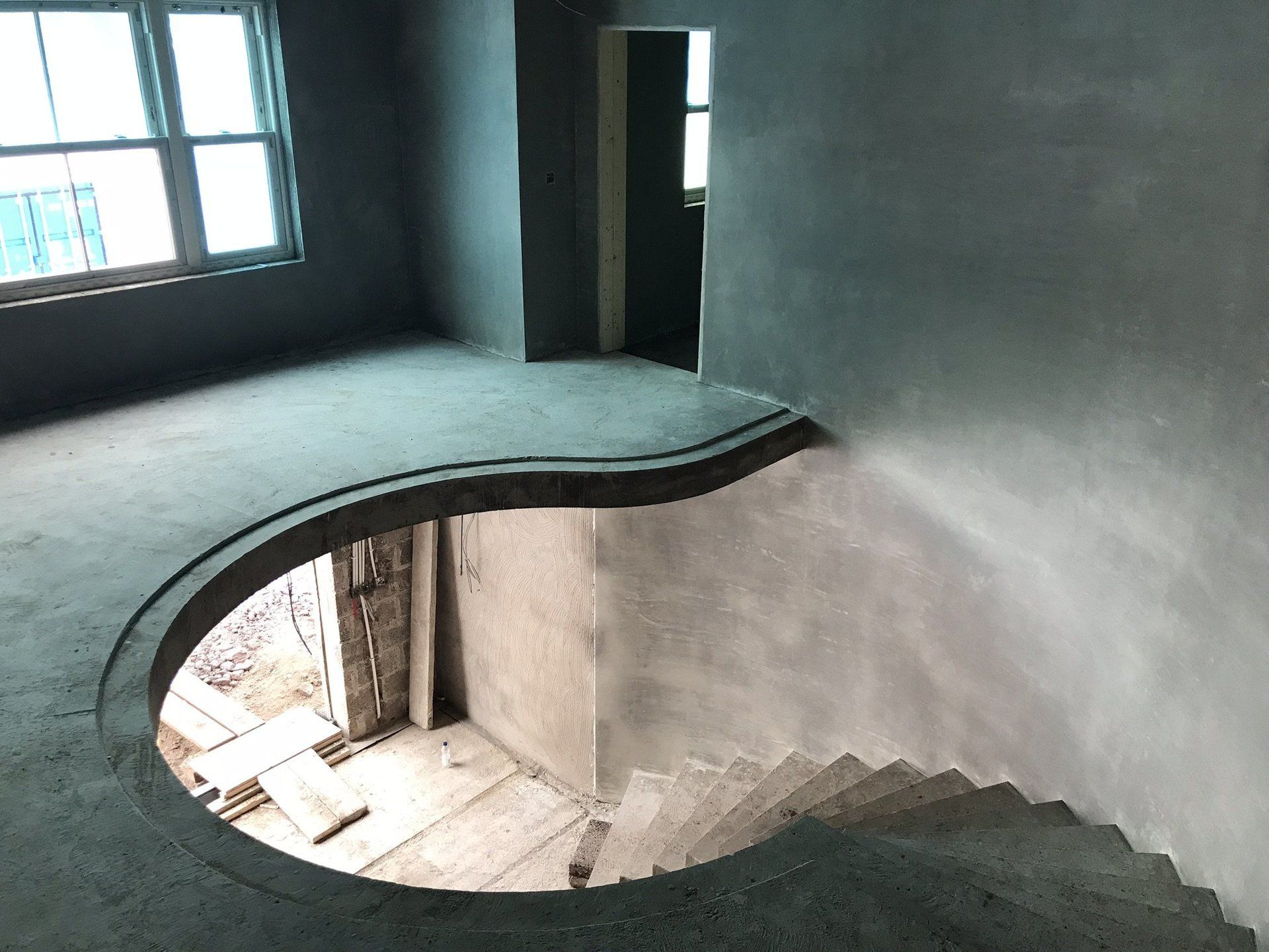 An empty room with a spiral staircase in the middle