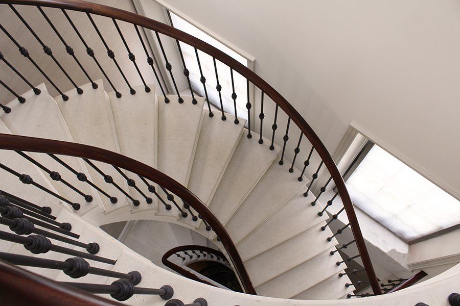 Looking up at a spiral staircase with a wooden railing