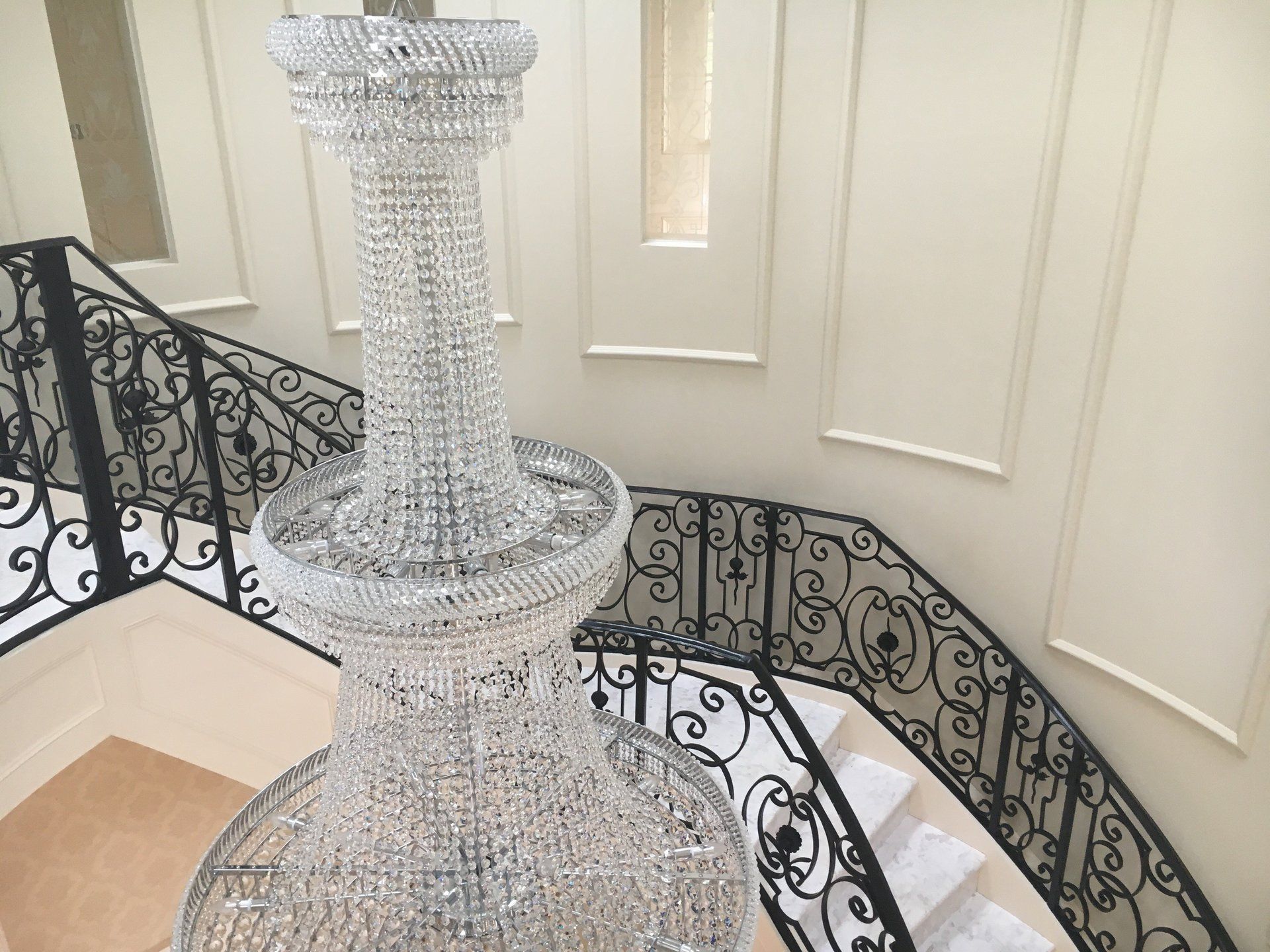 A large chandelier is hanging from the ceiling of a staircase