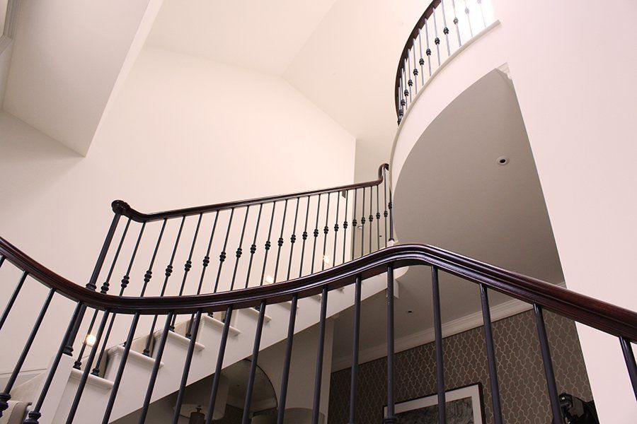 Looking up at a curved staircase with a wrought iron railing