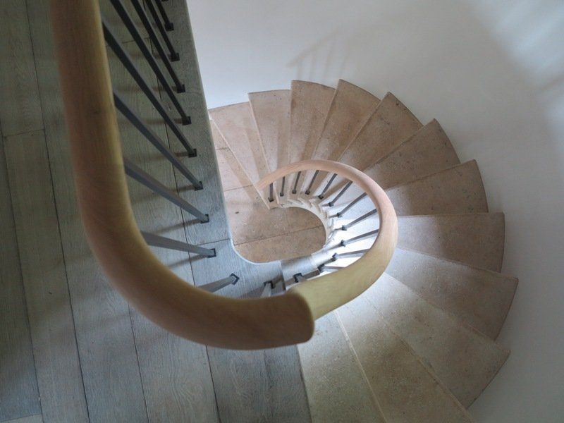 A spiral staircase with wooden steps and a metal railing
