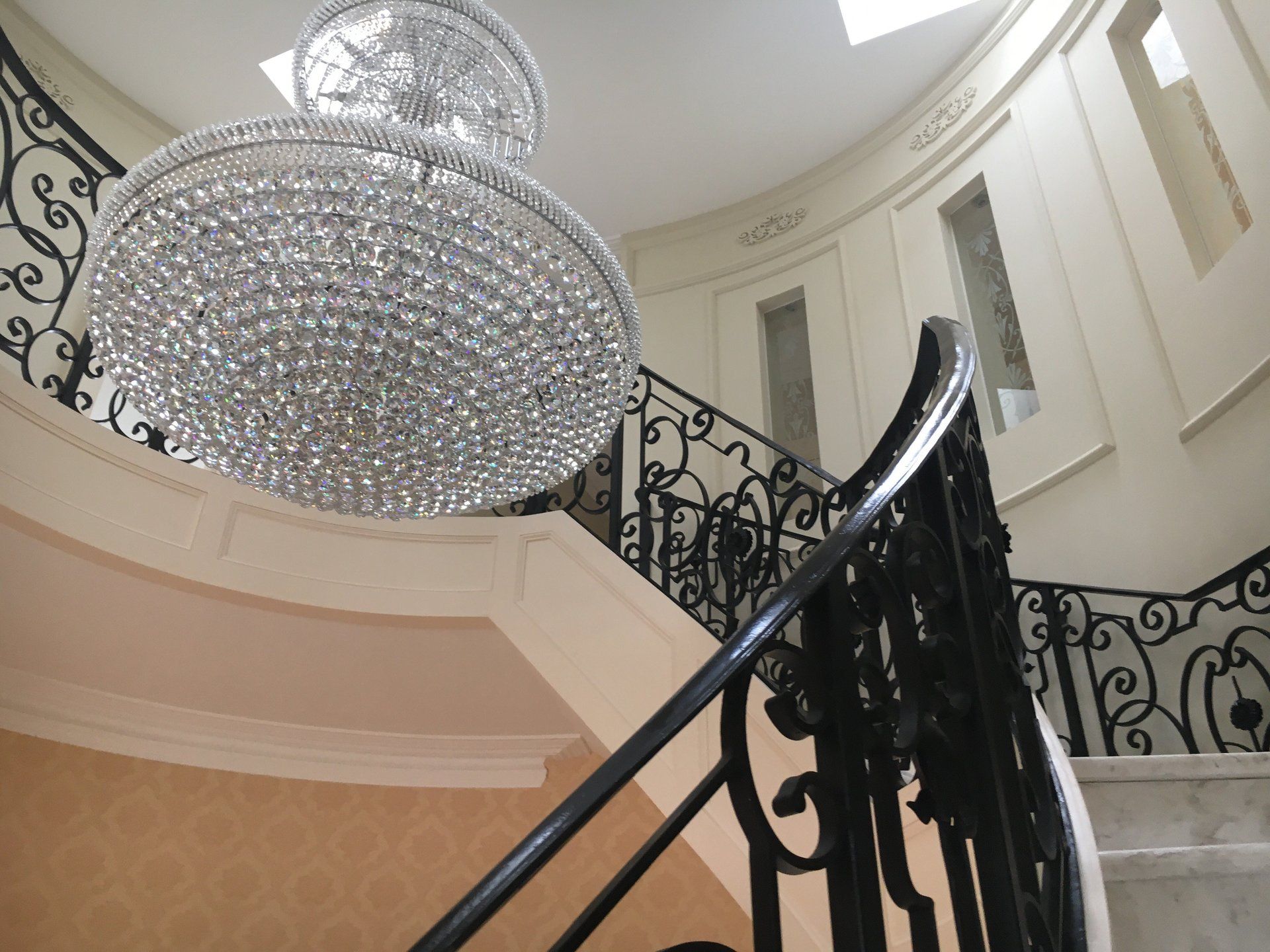 A staircase with a chandelier hanging from the ceiling