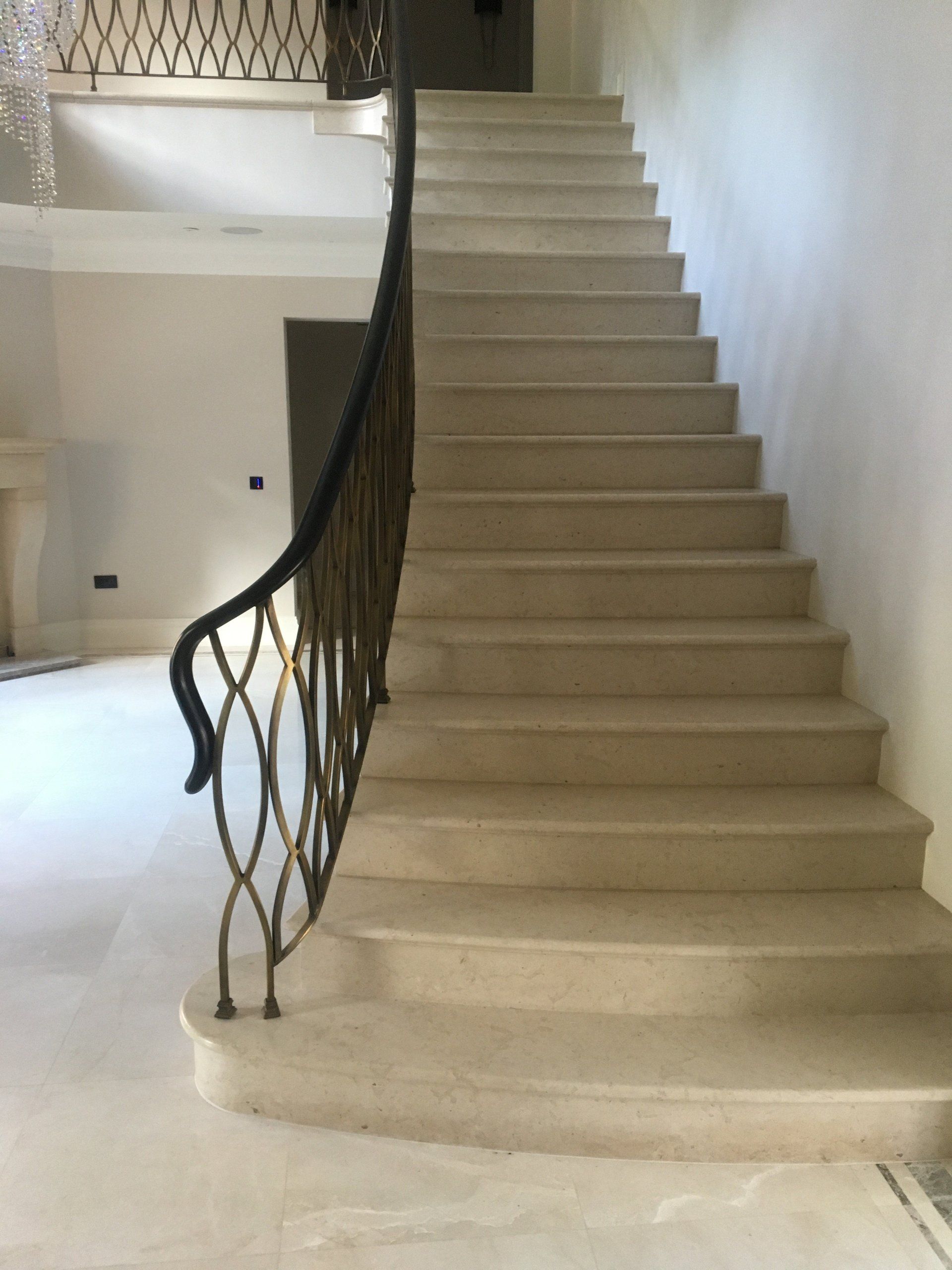 A staircase with a wrought iron railing in a house.