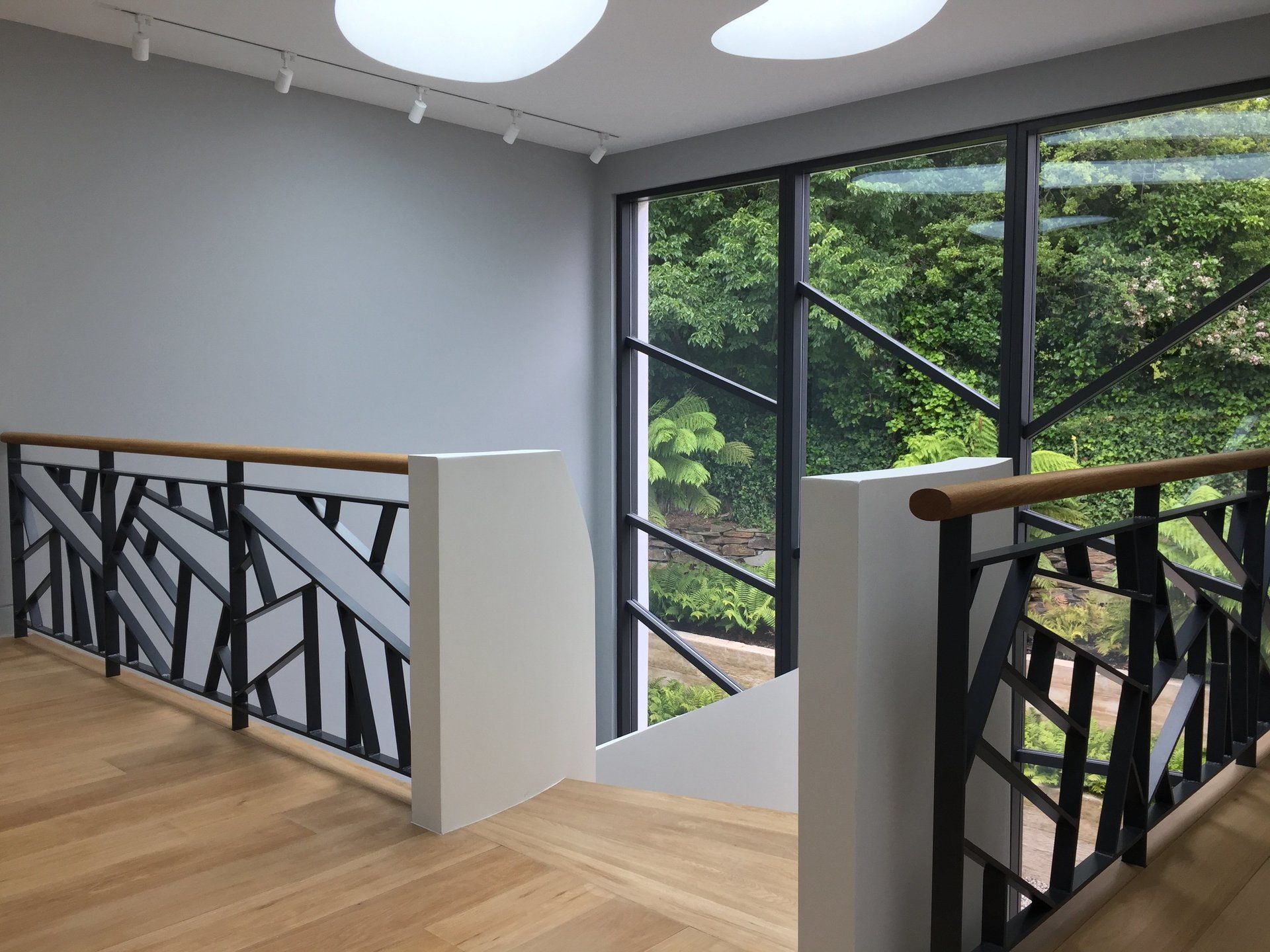 A staircase with a black railing and a large window.