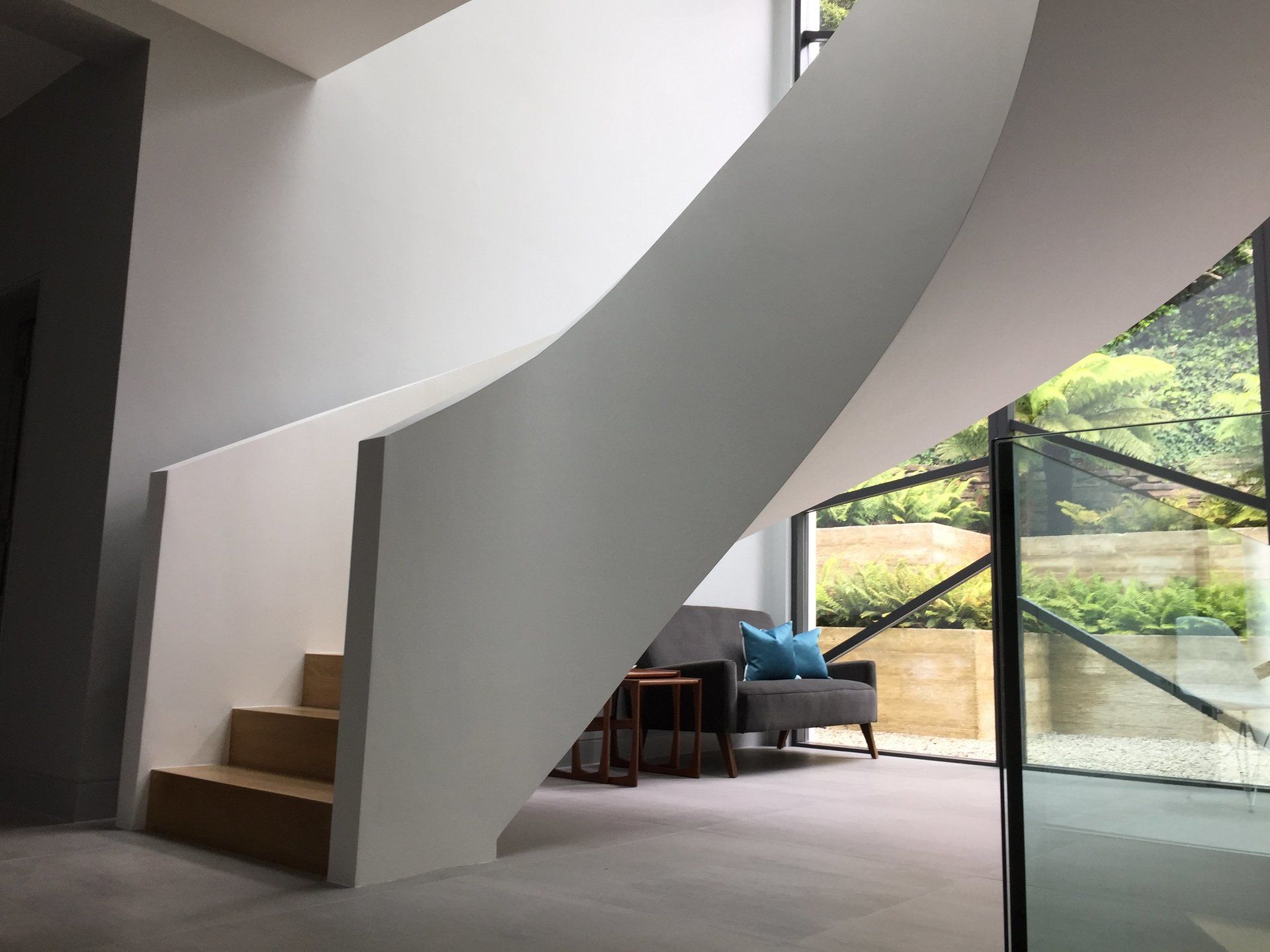 A curved staircase in a living room with a couch.
